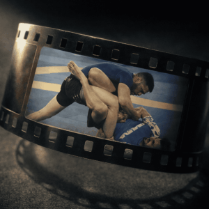 Scène de combat de grappling mise en valeur dans une pellicule de cinéma avec une ambiance sombre et dynamique, illustrant un service de montage vidéo professionnel.